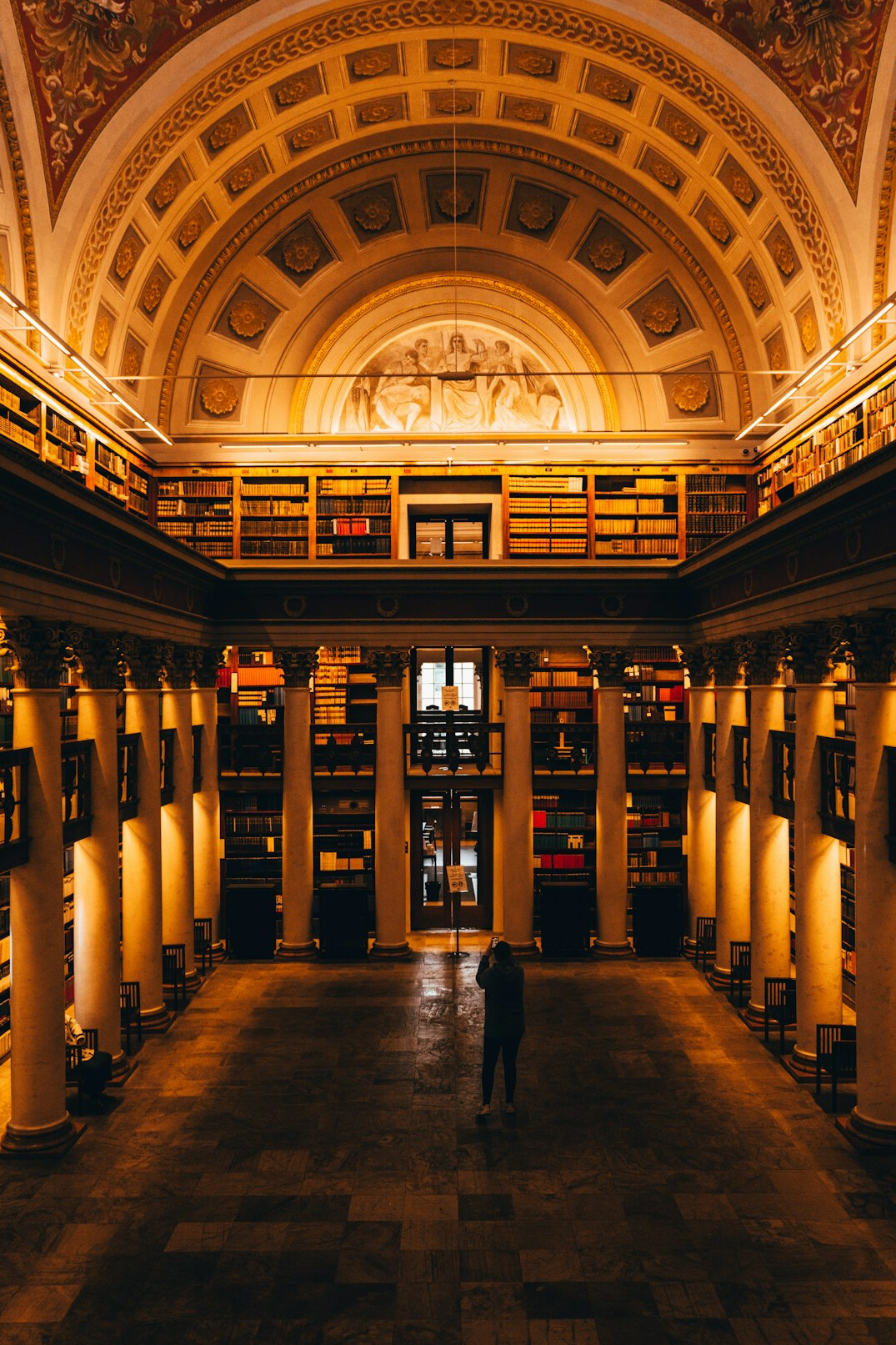 Historic library with tall wooden bookshelves and warm light